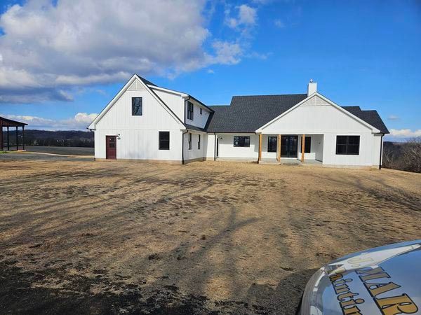 A white house with a black roof is being built