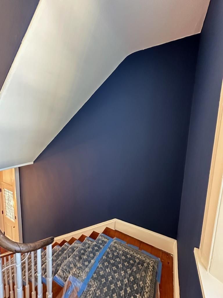 A staircase with blue walls and a rug on the steps