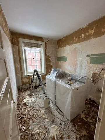 A laundry room with a washer and dryer in it is being remodeled.
