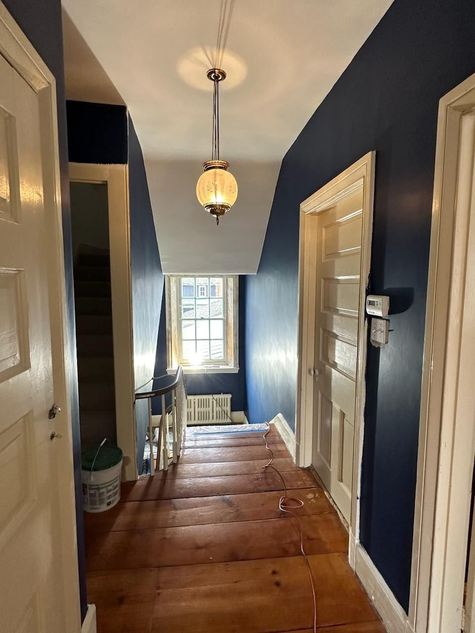 A hallway with wooden floors and blue walls