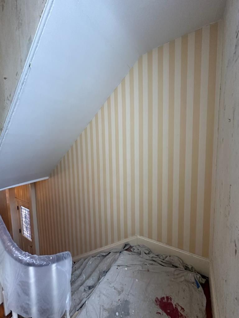 A room with a staircase and a striped wall.