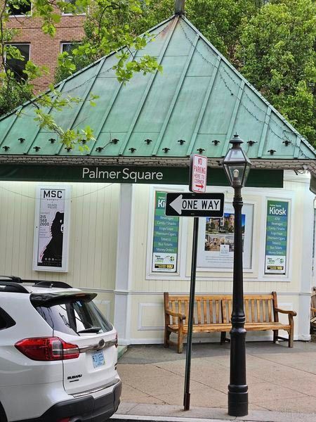 A white suv is parked in front of palmer square
