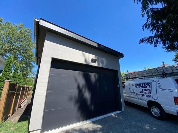 A white van is parked in front of a garage door.