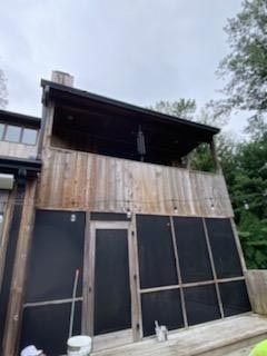 A house with a screened in porch and a balcony.