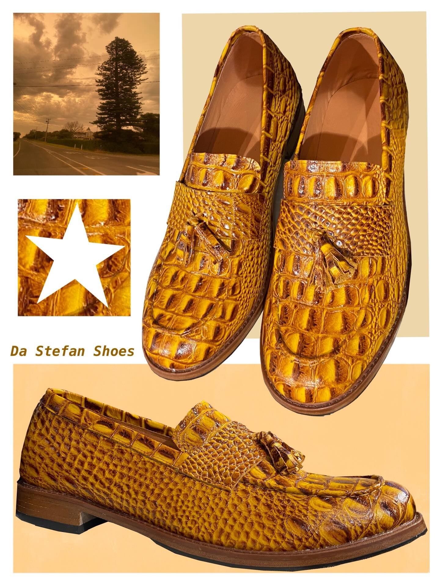 Golden crocodile-textured loafers; inset: road, tree, cloudy sky; star graphic; 