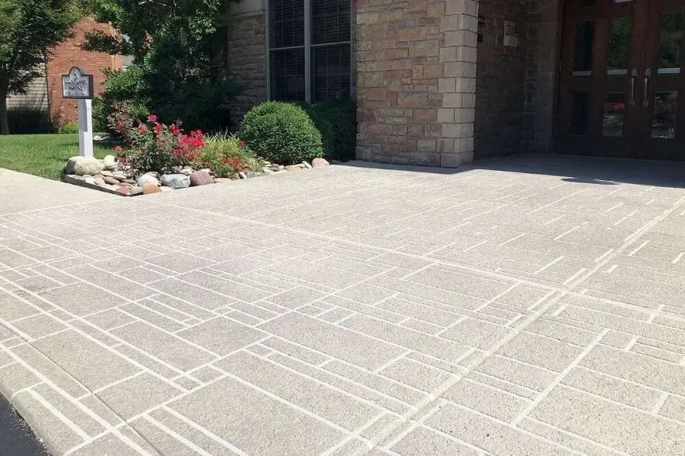 A brick building with a concrete driveway in front of it.