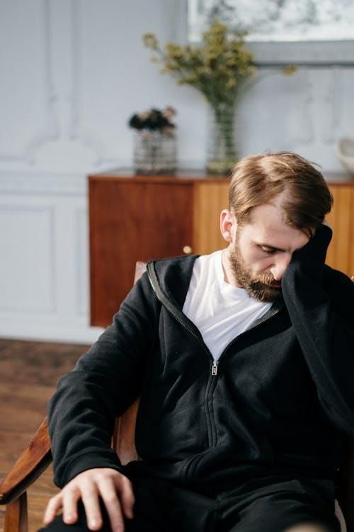 a man in a black jacket sitting at the office.