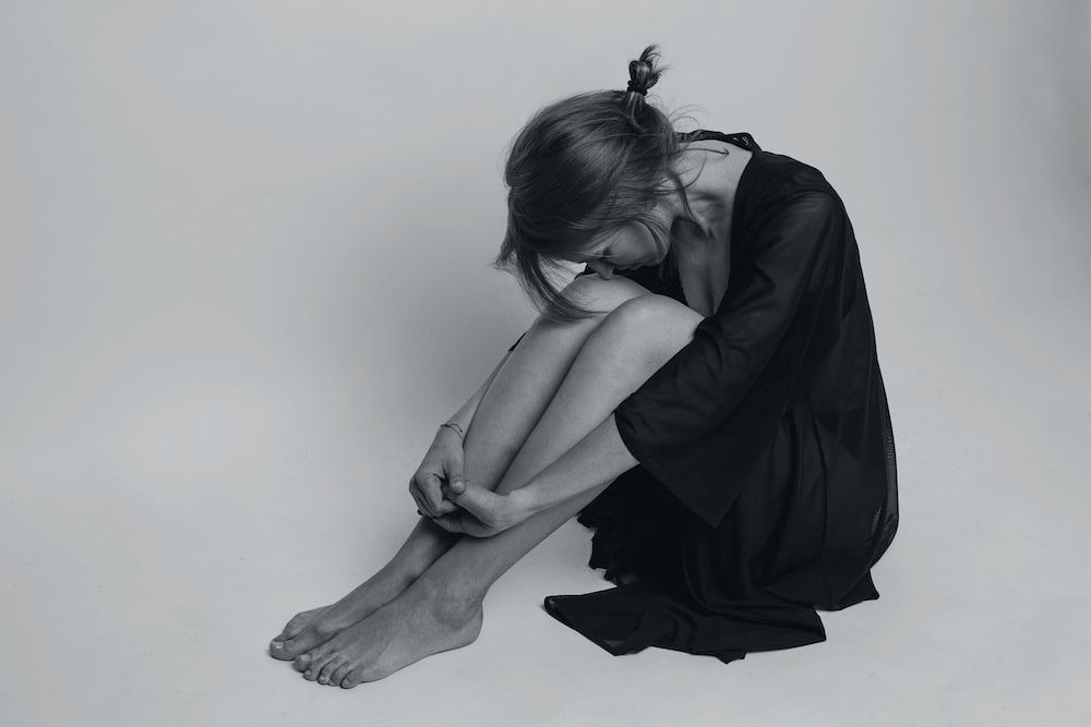 A depressed woman sitting on the floor