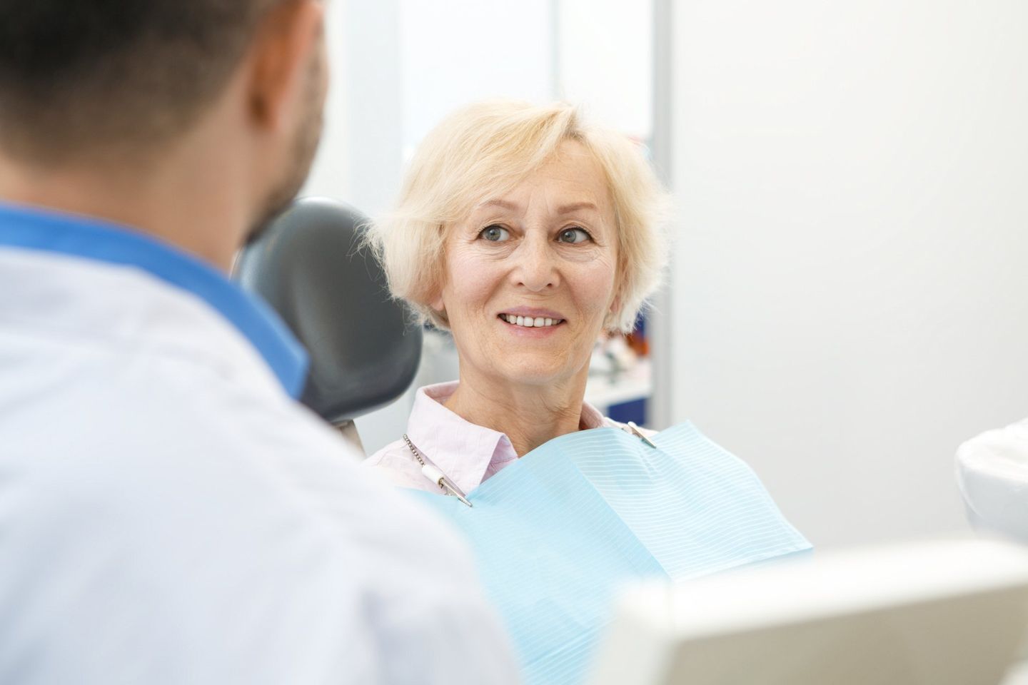 Senior Woman Smiling Listening To Her Dentist - Dental Treatments in Port Macquarie, NSW
