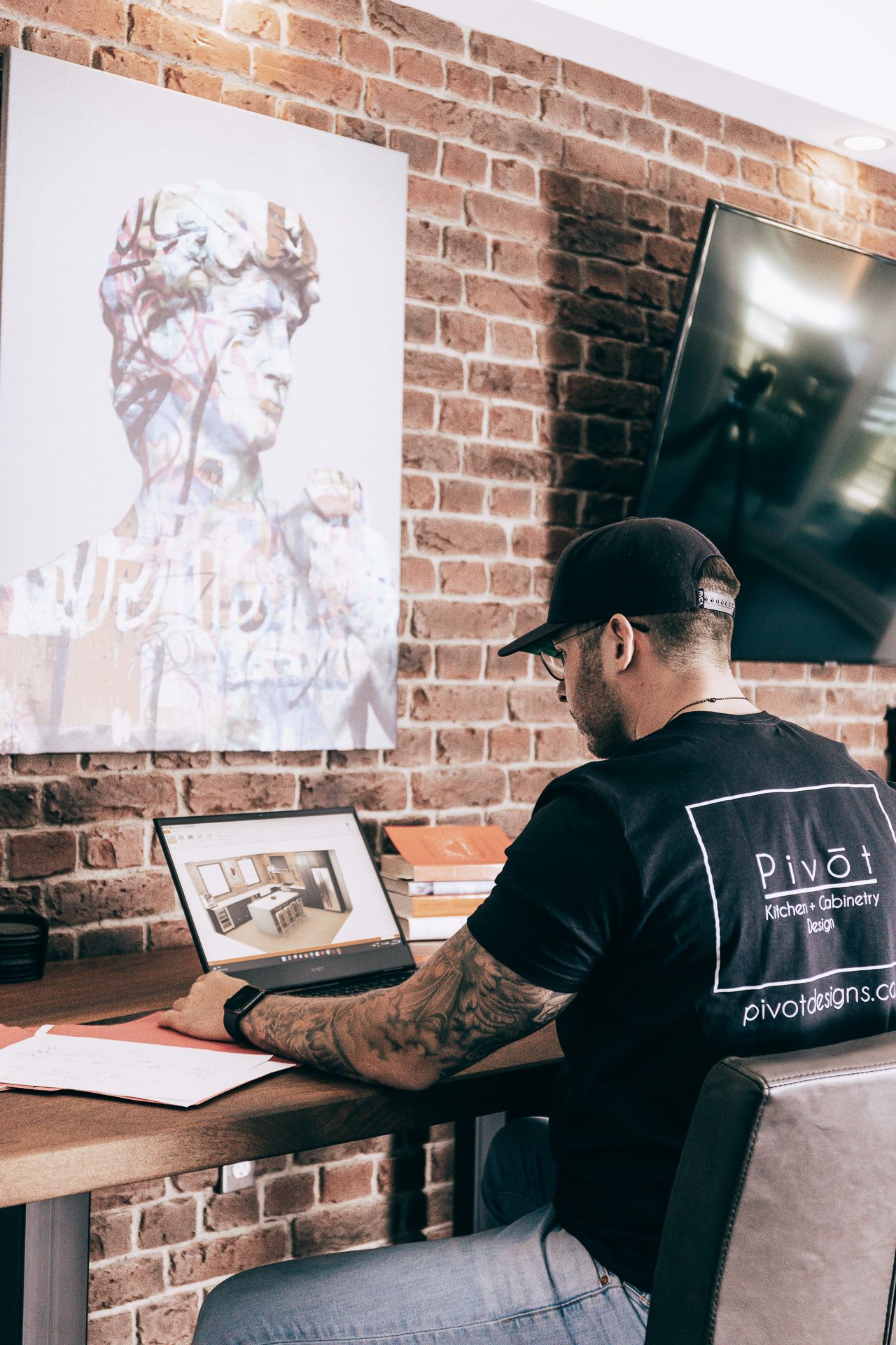 Owner of Pivot working on laptop 3D rendering design