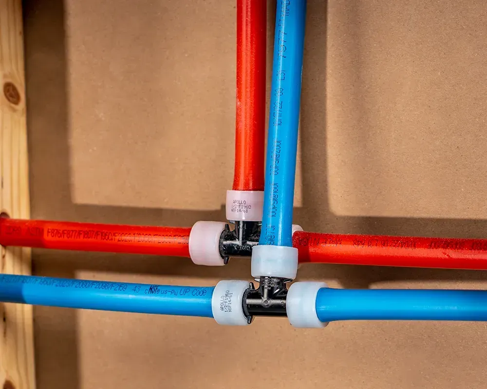 Red and blue PEX plumbing pipes joined with white fittings