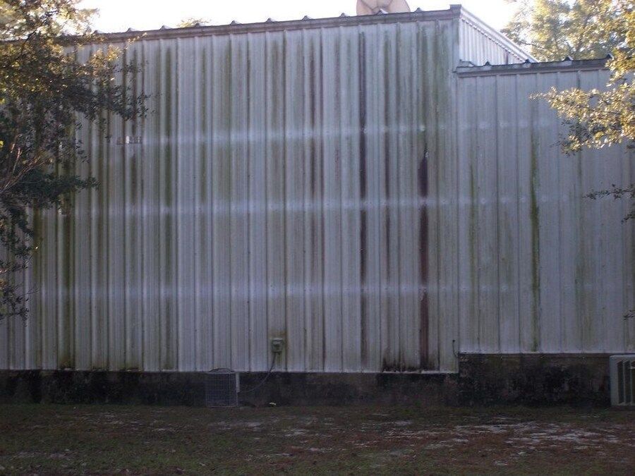 A white building with a lot of moss on it