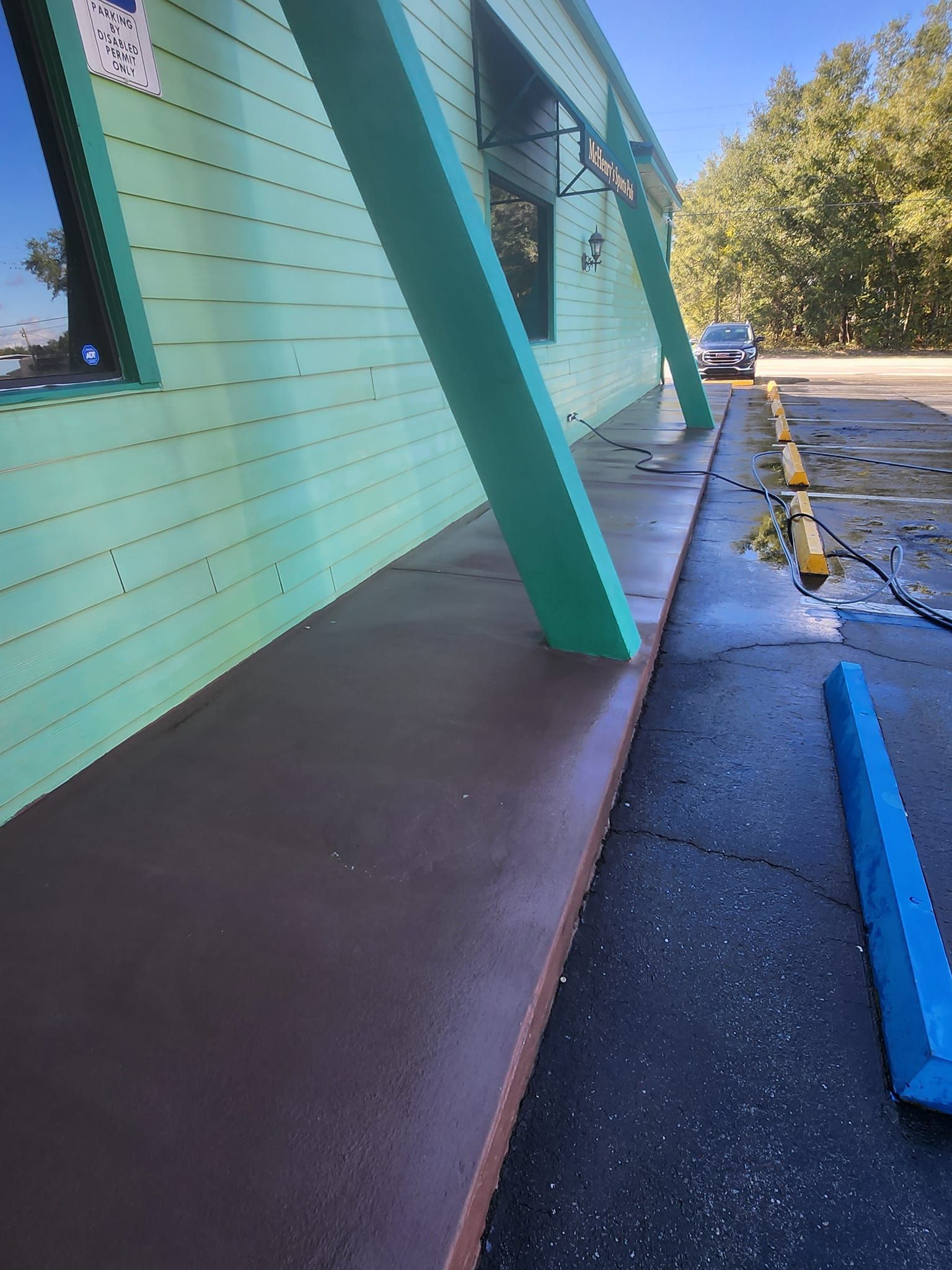 A car is parked in a parking lot next to a building.