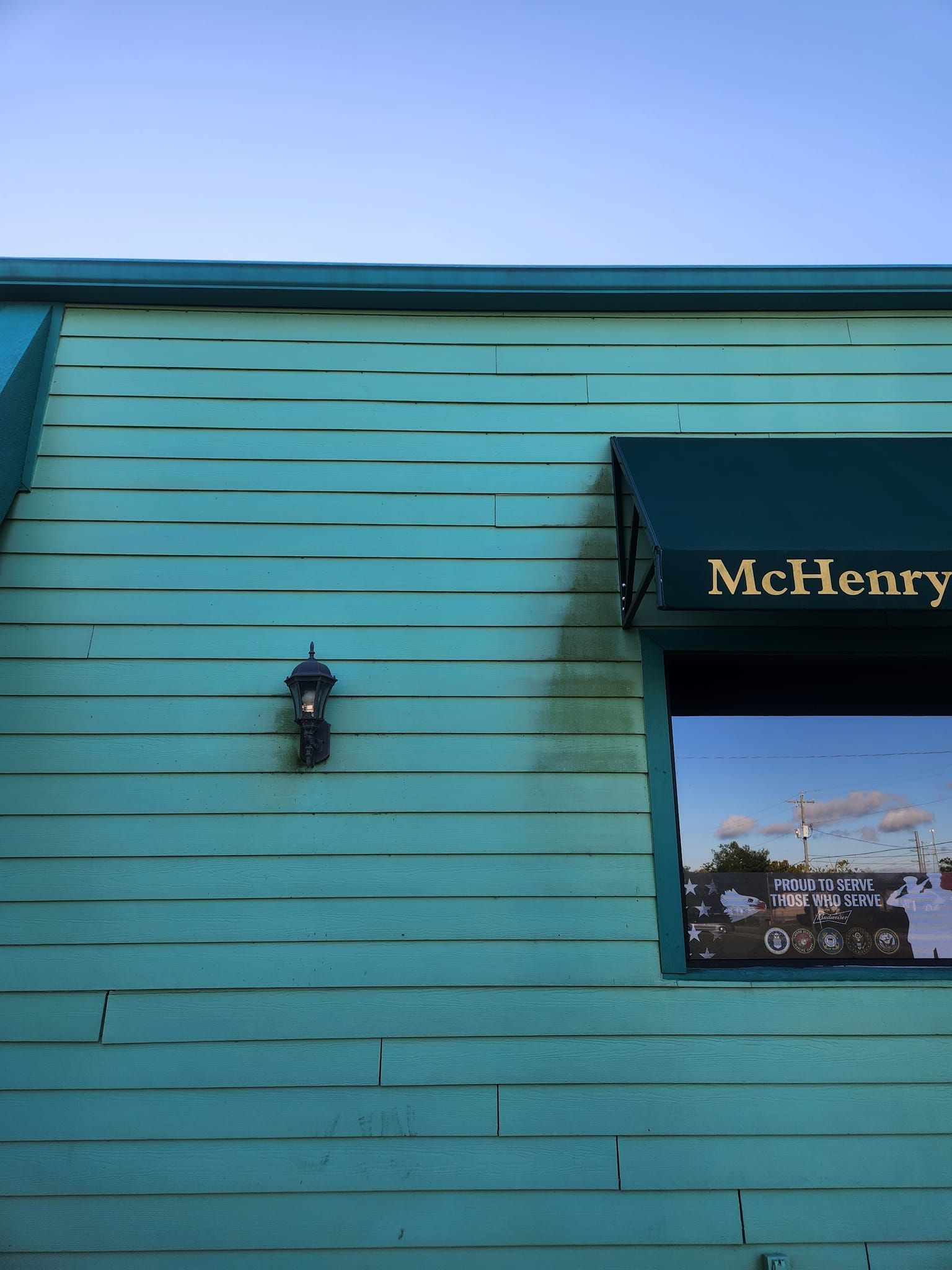 A green building with a black awning that says mchenry