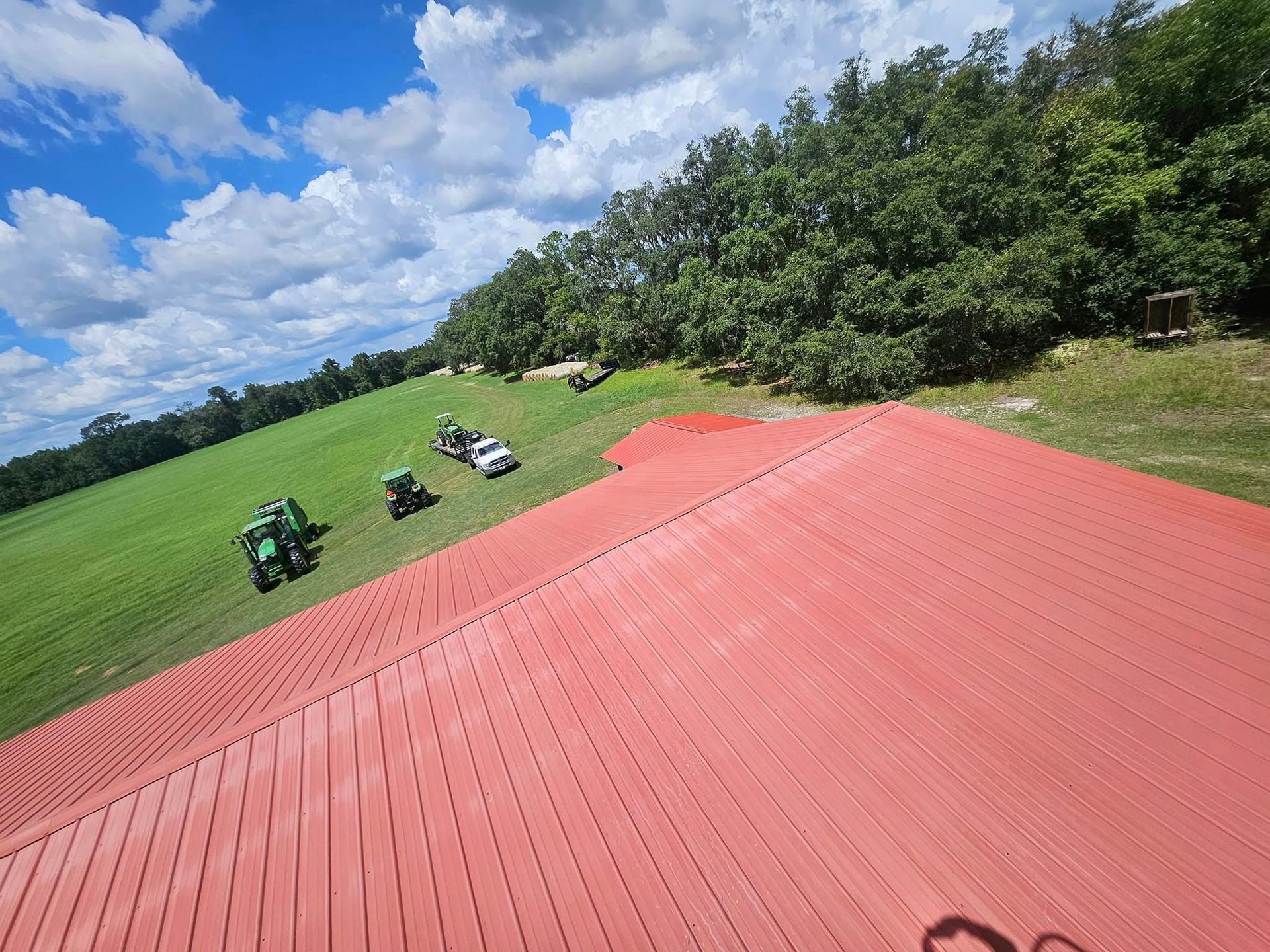 A red roof with tractors parked on it in a field.