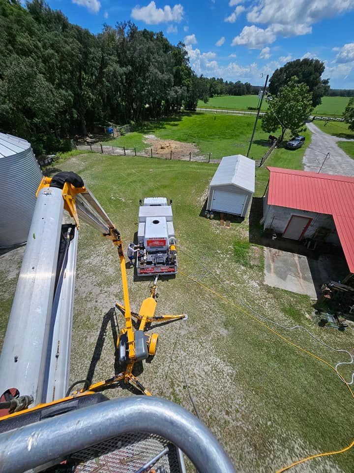 An aerial view of a truck and a crane in a field.