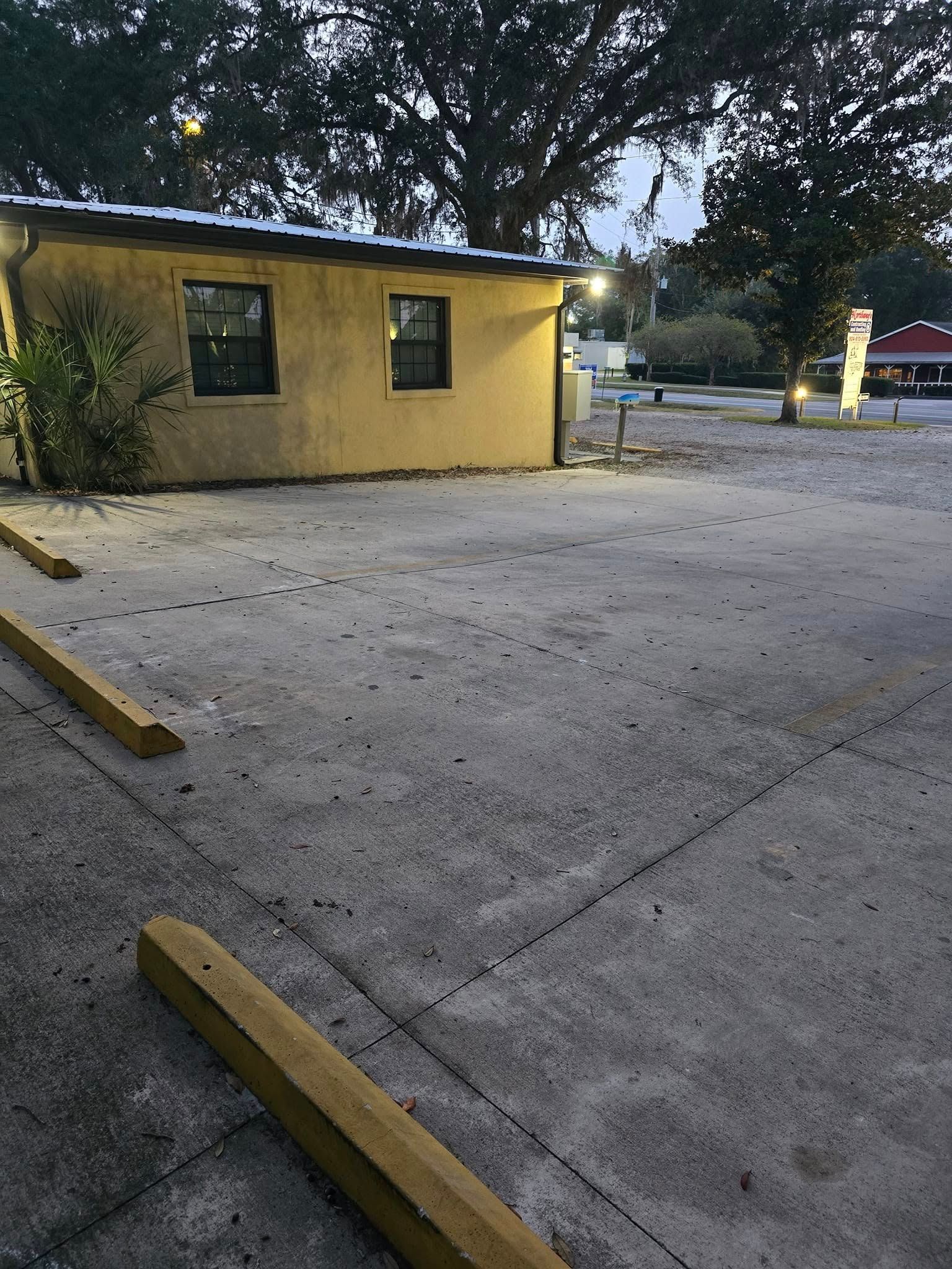 A yellow building with a parking lot in front of it