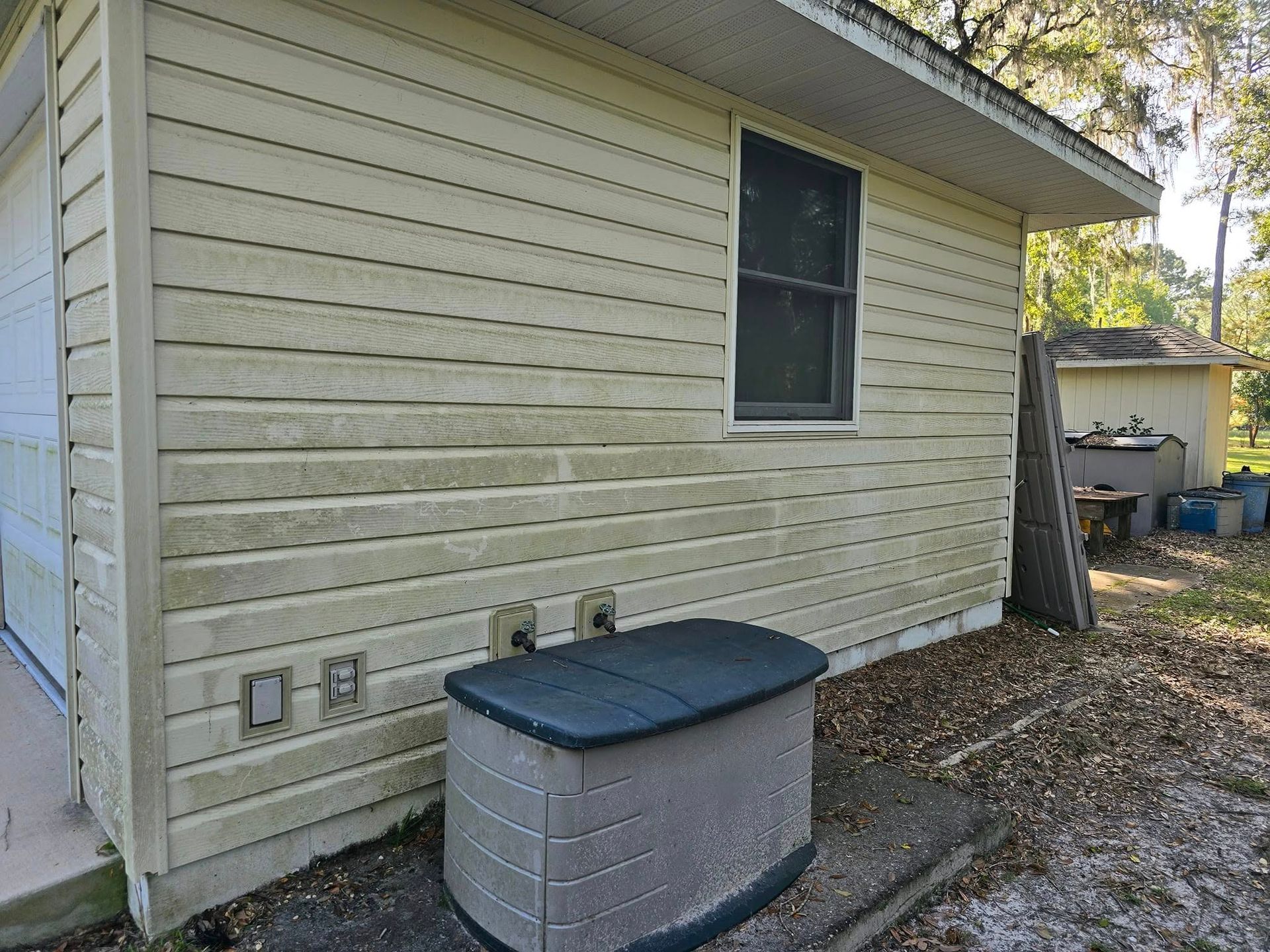 A white house with a black box on the side of it.