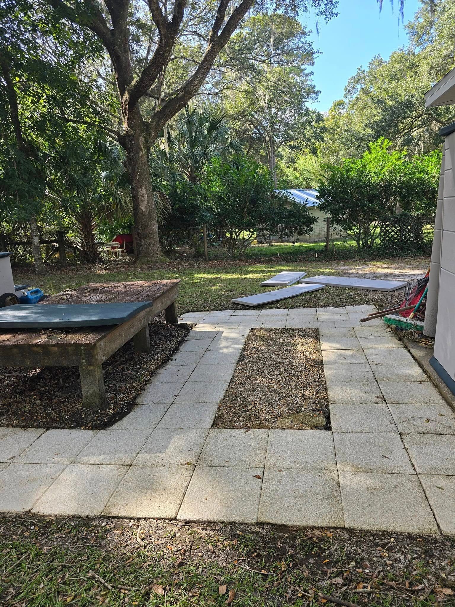 A patio with a table and trees in the background.