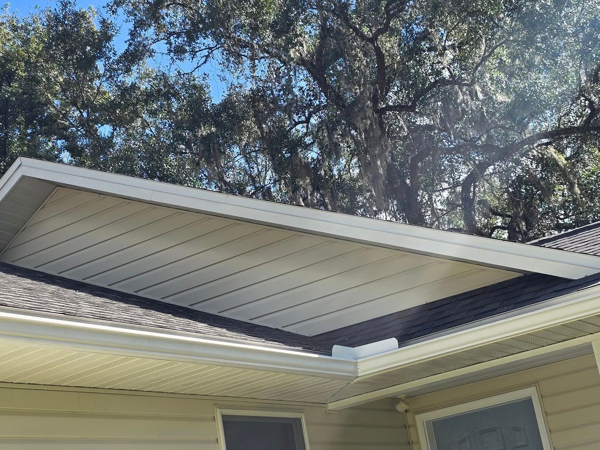 The roof of a house with trees in the background.
