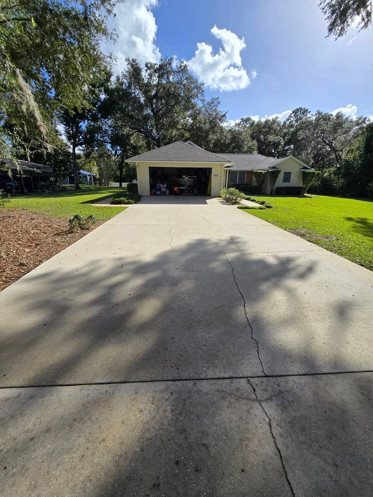 A concrete driveway leading to a house with a garage.