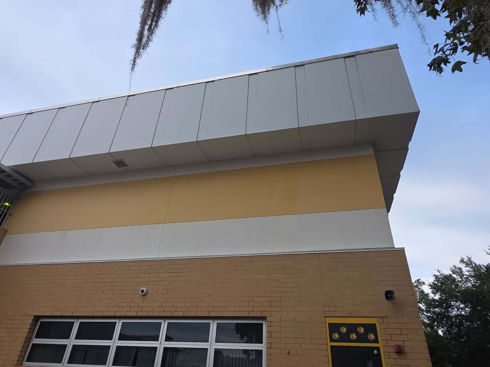 A statue of a soldier is standing next to a wooden bench.