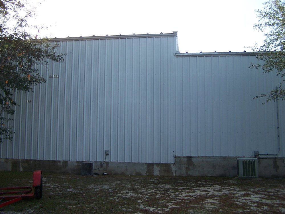 A large house with a lot of windows and a garage on a rainy day.