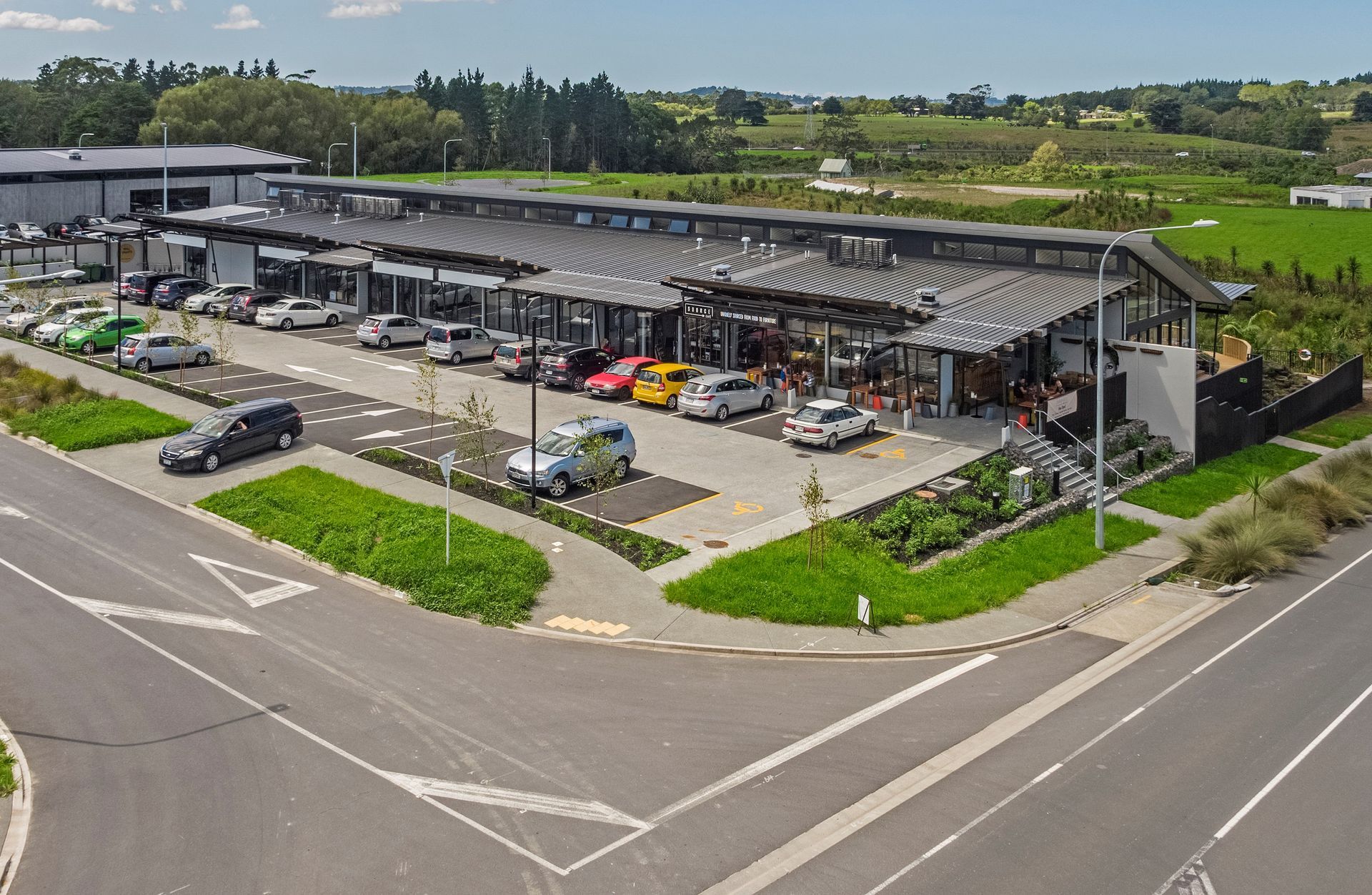 An aerial view of a parking lot with cars parked in front of a building.