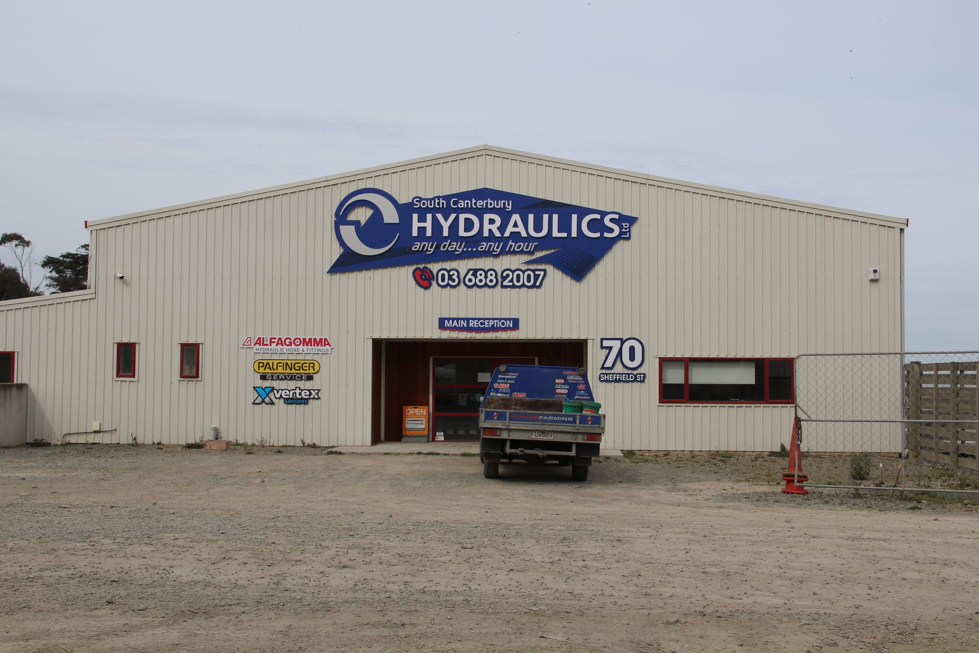 A truck is parked in front of a building that says hydraulics