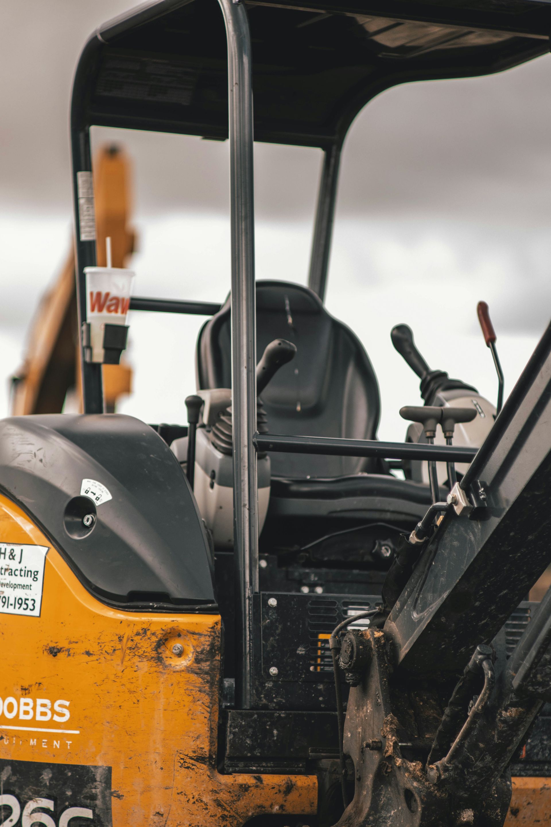 A close up of a yellow and black tractor with a black seat.