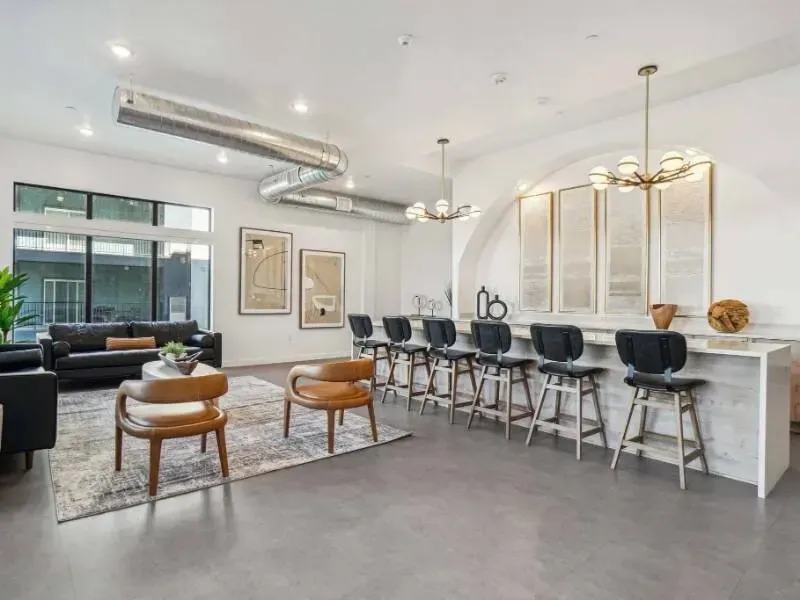 Modern apartment community lounge with a bar-height counter, stools, and seating.