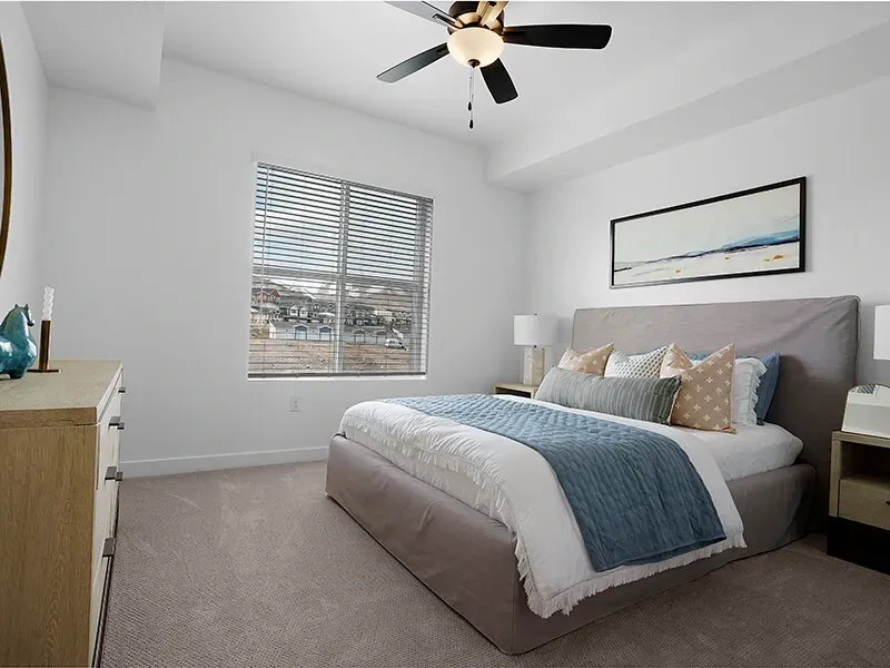 Bedroom with a queen bed, two nightstands, dresser, and a window with blinds.