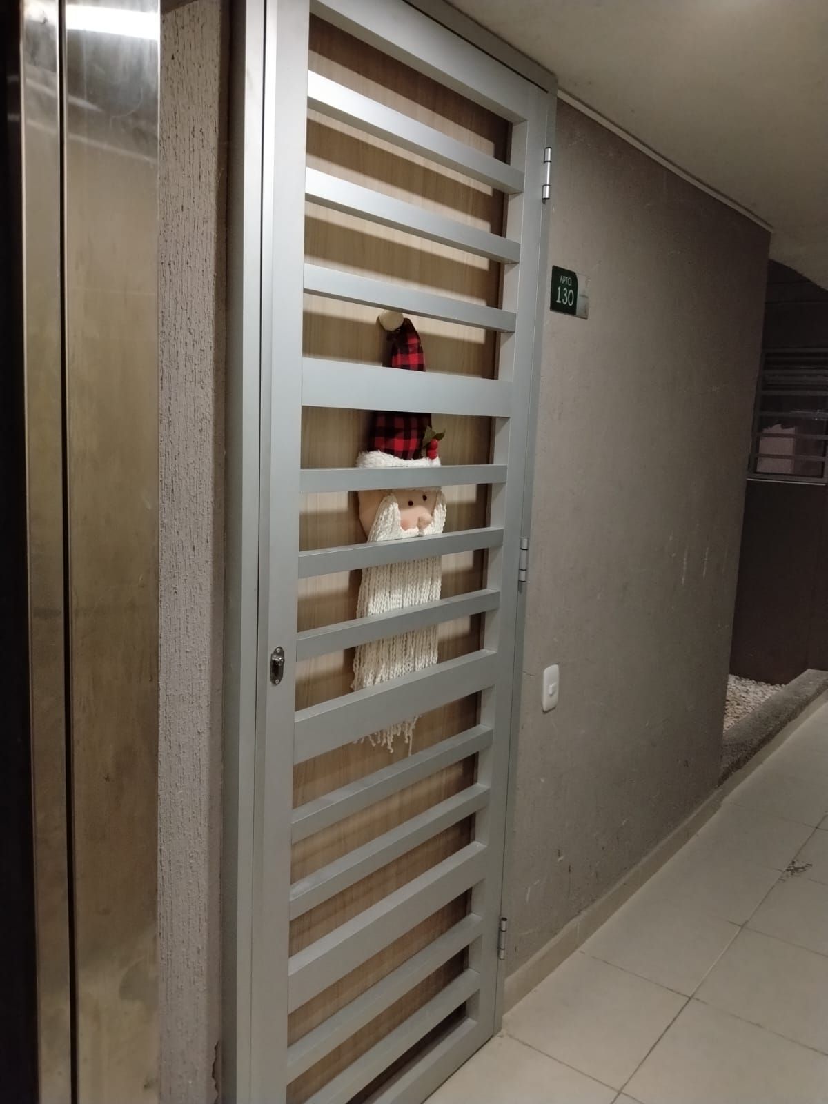 Puerta decorada con figura de Papá Noel, listones, pasillo y señal de salida.