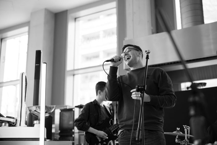 A man is singing into a microphone in a black and white photo.