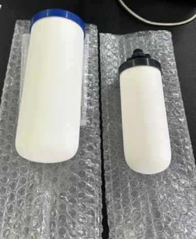 Two White Water Filters, One With a Blue Lid, the Other Black, on Bubble Wrap — NT Water Filters In Winnellie, NT