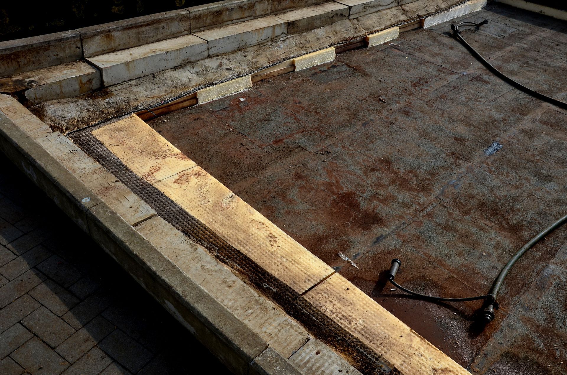 A man is installing tiles on a floor with a tile cutter.