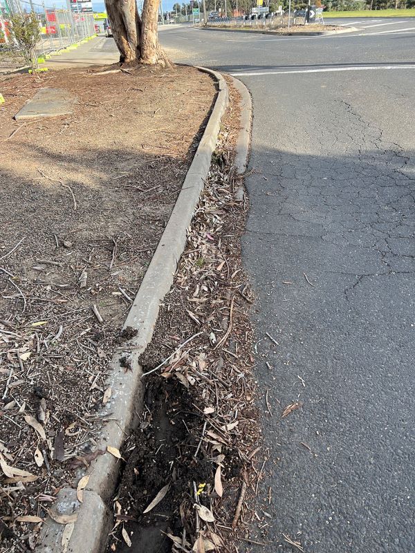 A Curb on the Side of a Road With a Tree in the Background — Fig Facility Services in Lara, VIC