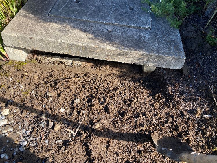 A Person is Digging in the Dirt Next to a Manhole Cover — Fig Facility Services in Lara, VIC