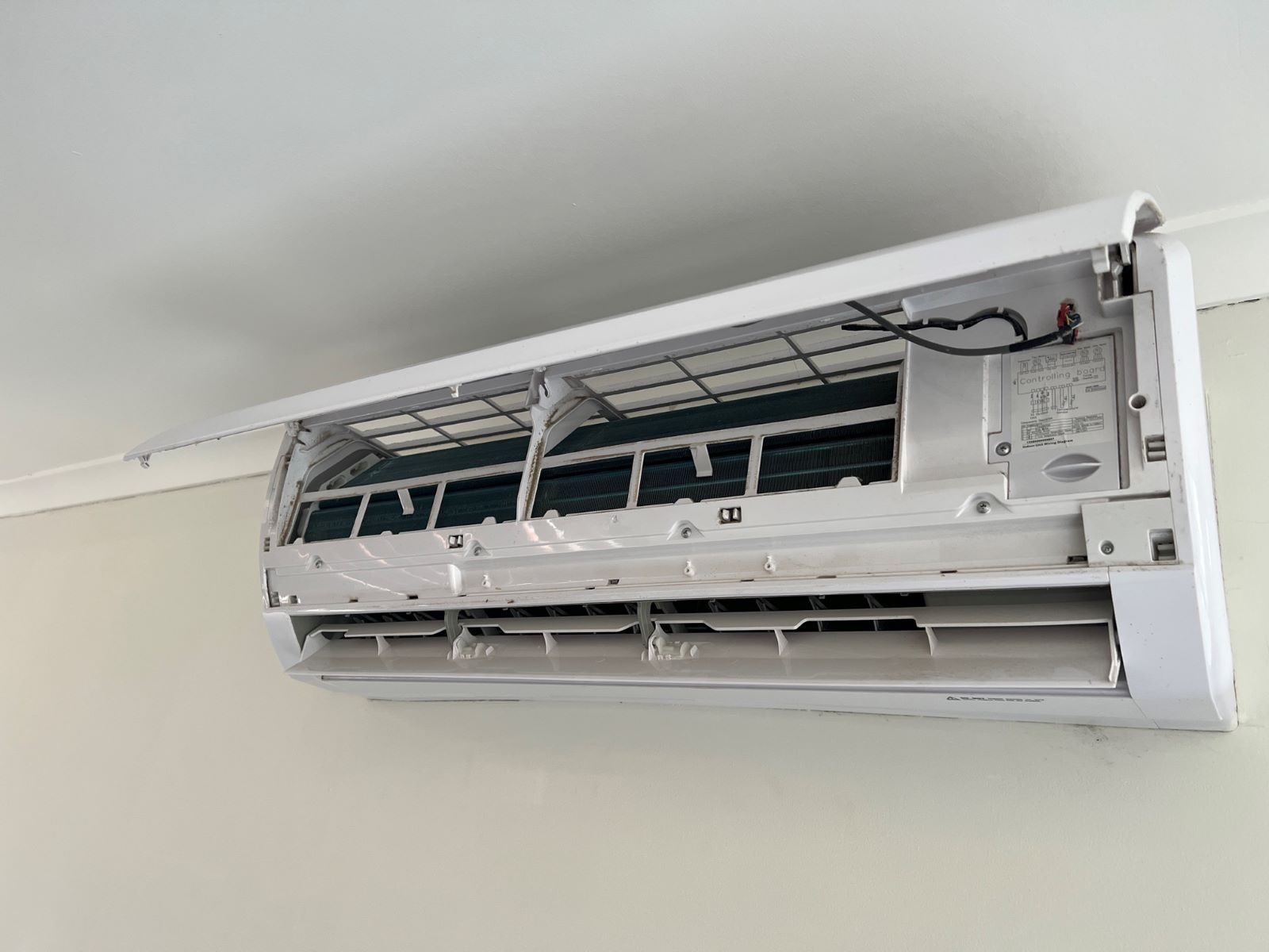 A White Air Conditioner is Hanging From the Ceiling in a Room — Fig Facility Services in Lara, VIC