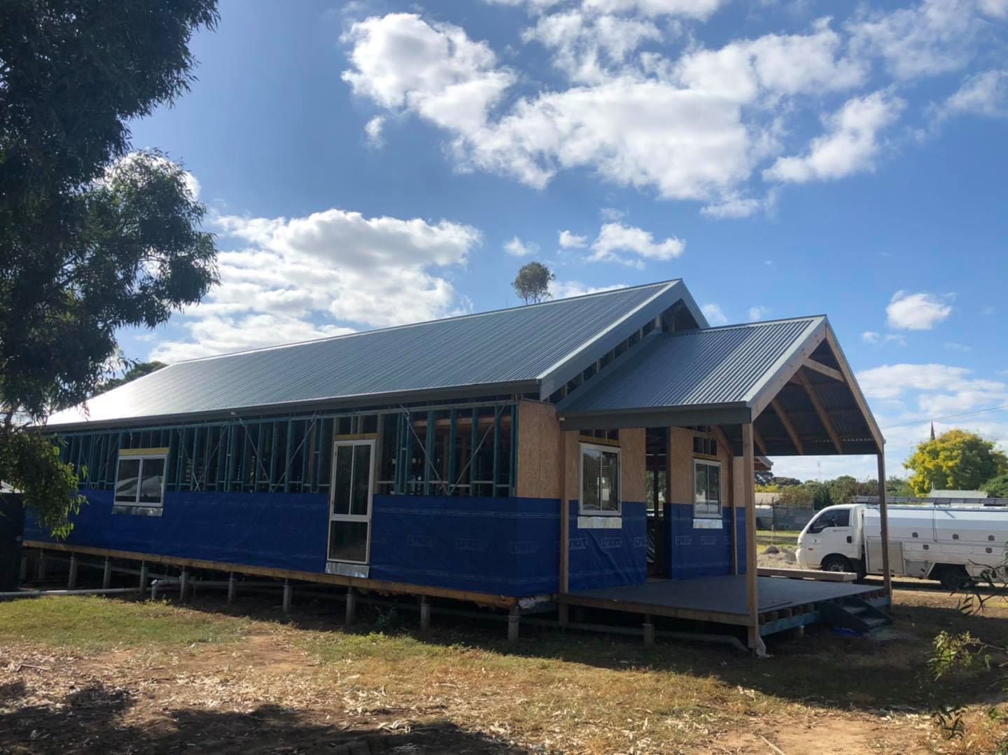 A Large Building With a Water Tank in Front of It — Fig Facility Services in Lara, VIC