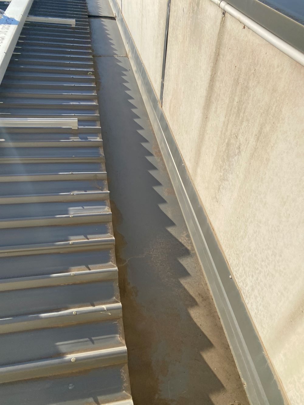 A Drain on the Side of a Building With Stairs in the Background — Fig Facility Services in Lara, VIC