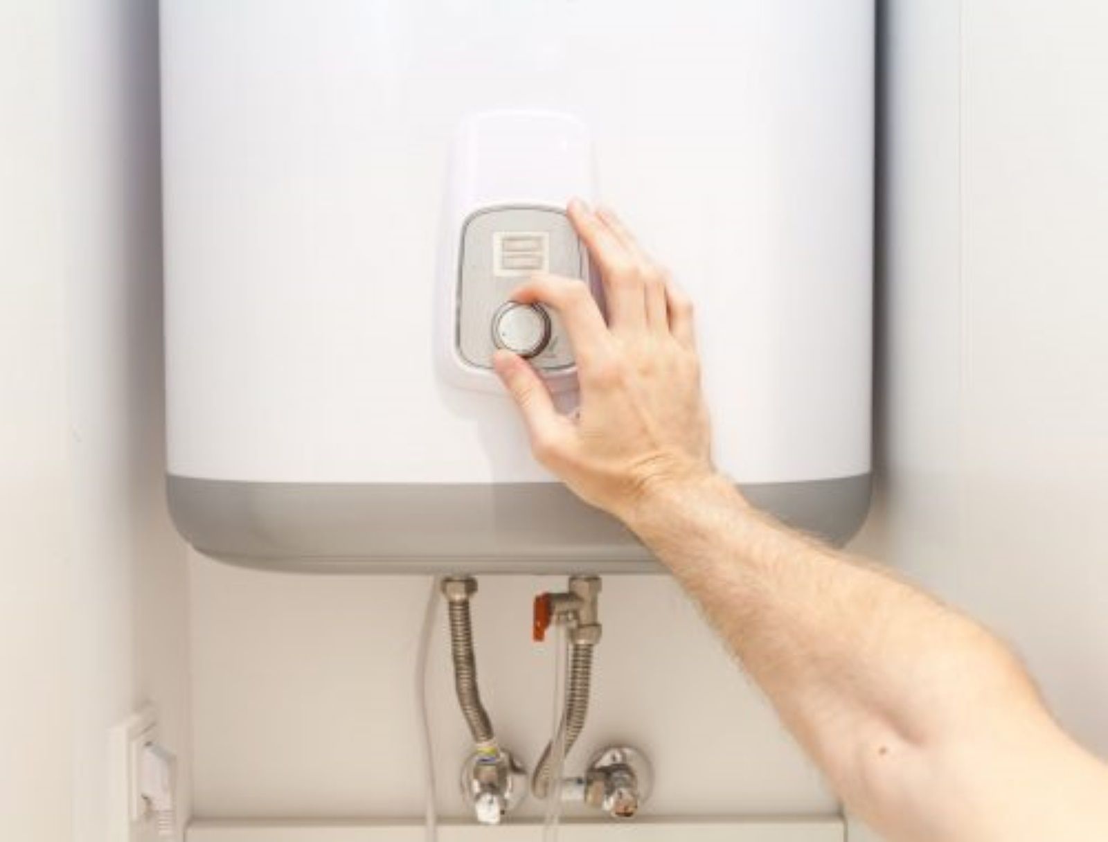 A Person is Pressing a Button on a Water Heater — Fig Facility Services in Lara, VIC