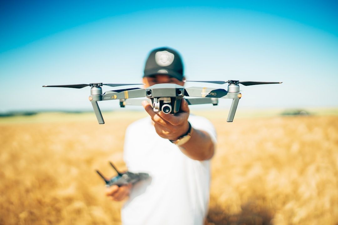 Drone pilot launching quadcopter in field
