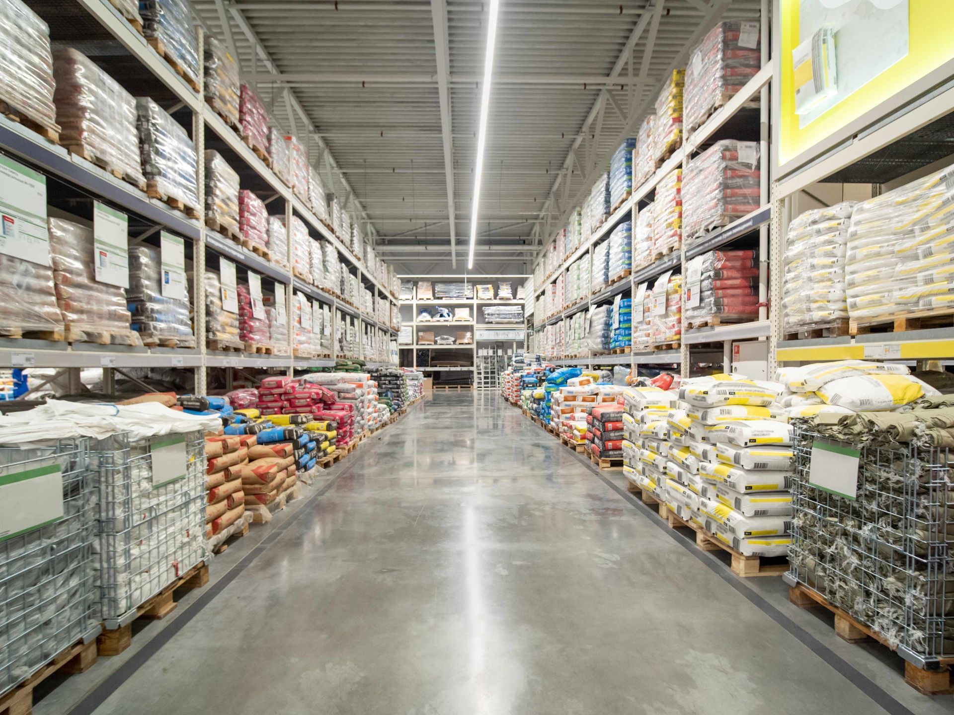 Warehouse aisle with high shelves filled with various packaged products.