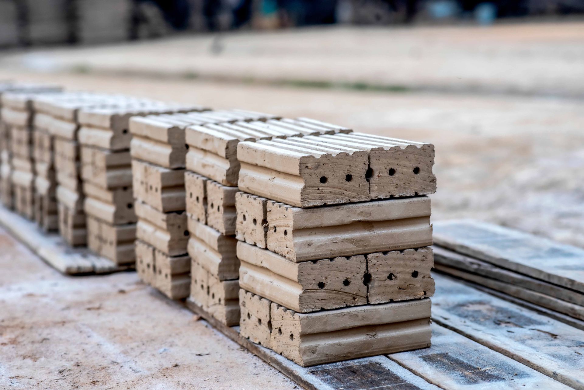Stacks of beige bricks on a concrete surface, ready for construction.