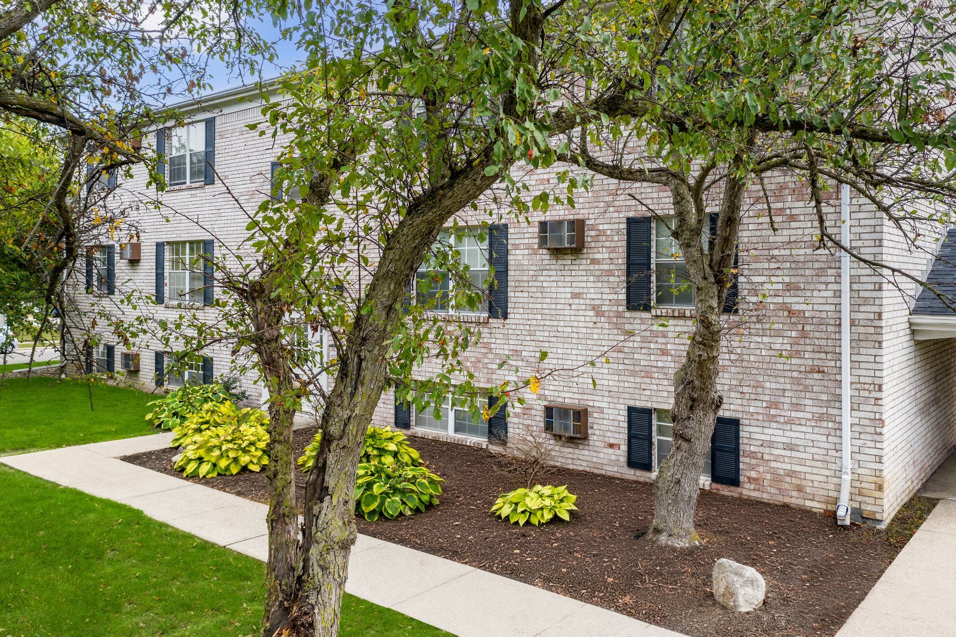 Photo of a three story building showing crisp, clean landscaping around it