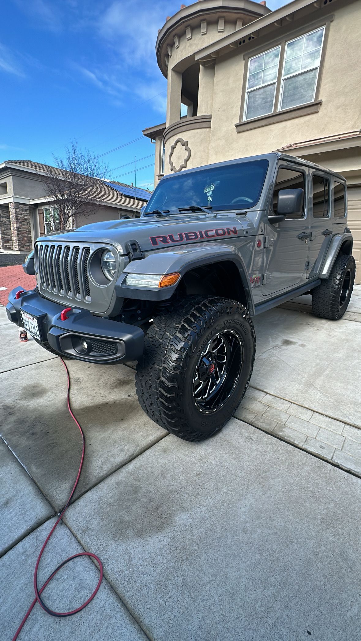 A jeep wrangler is parked in front of a house.