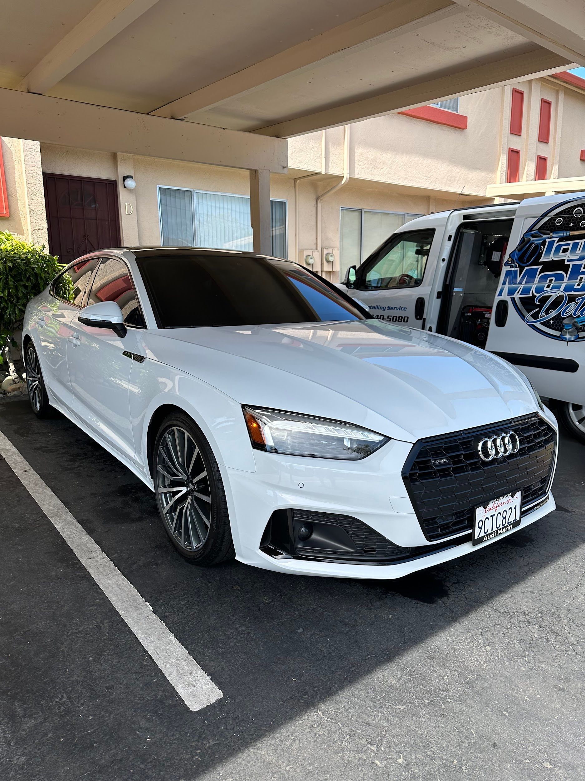 A white audi a5 is parked in a parking lot.