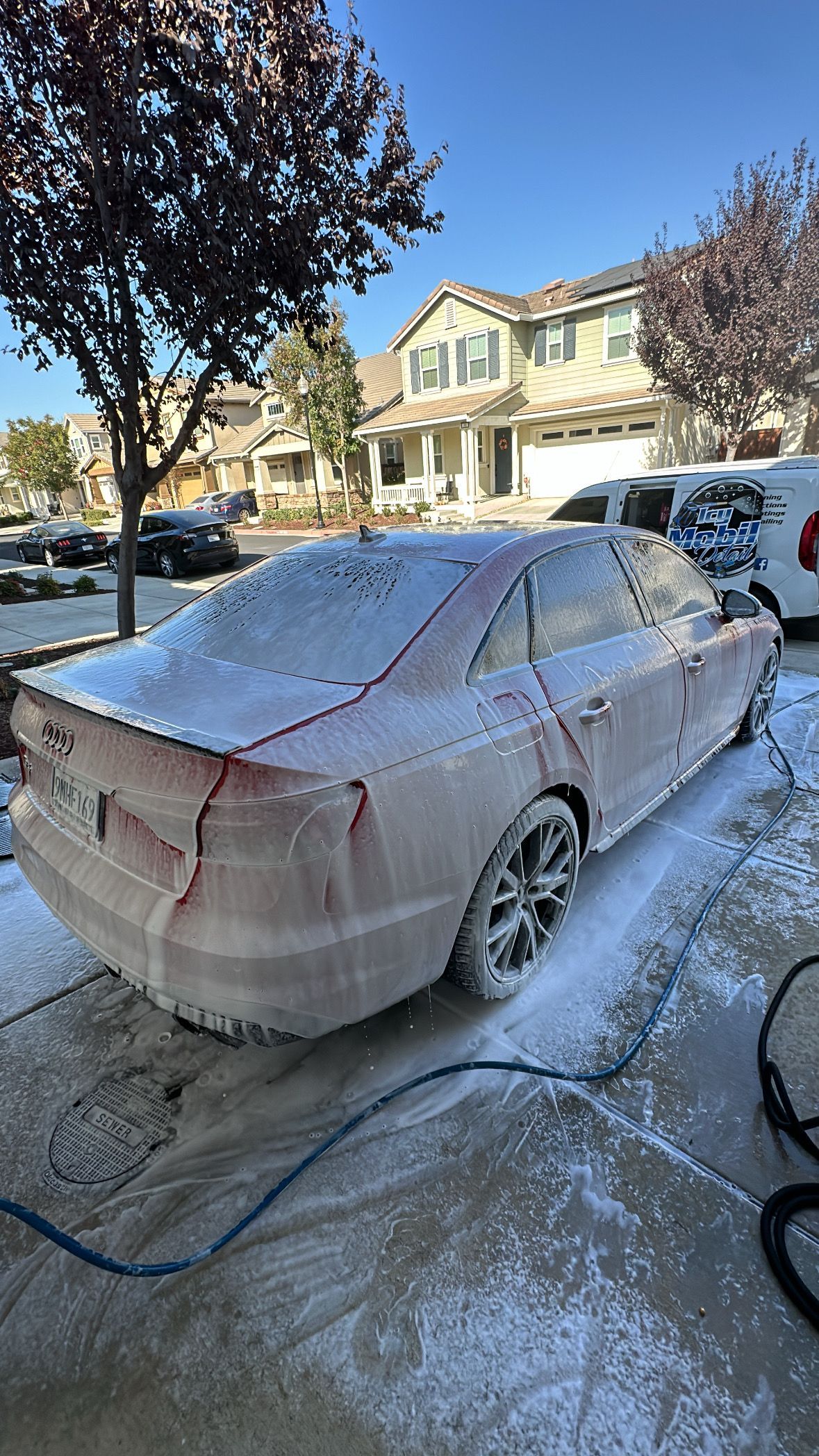 A car is covered in foam in a parking lot.