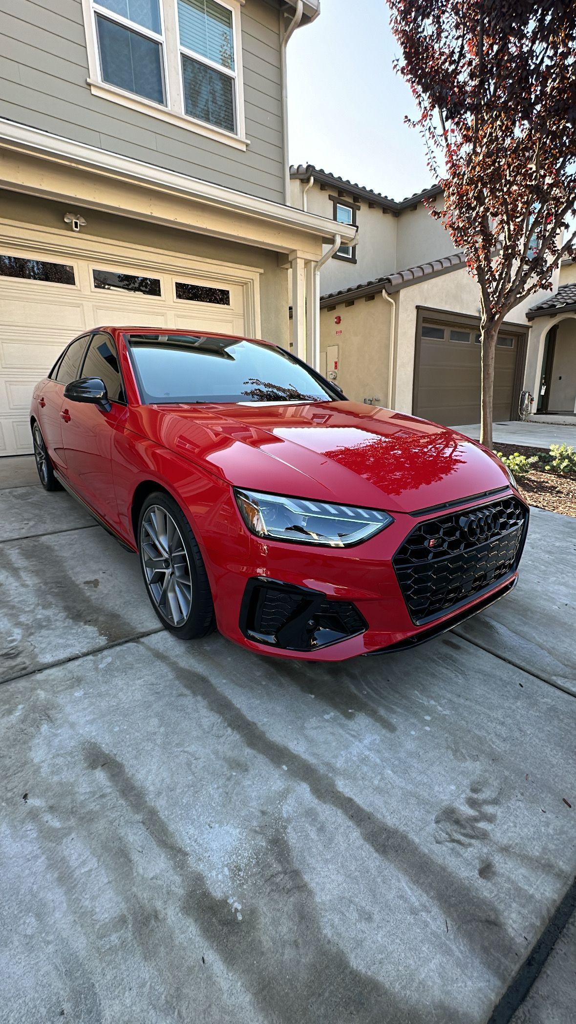 A red audi a4 is parked in front of a house.